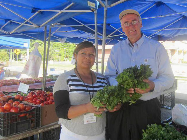 Former USDA Undersecretary Gus Schumacher, now with Wholesome Wave, is shown at a farmers market on the Quantico Marine Base in Virginia with Veronica Ochoa, who farms in Warsaw, Va. (Photo courtesy Wholesome Wave)