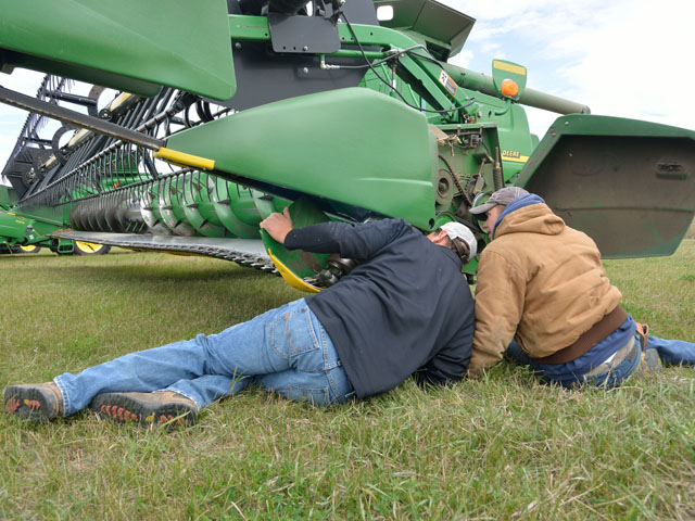 A broken header part was one more misstep in a day of trials for the Zenker family of Gackle, N.D. Here Chris Zenker and employee Taylor "Bubba" Lund check out the damage. (DTN/The Progressive Farmer photo by Jim Patrico)