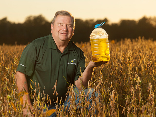 John Motter poses with soybean oil produced by the high-oleic soybeans he grows. EU approval of two GE high-oleic soybean traits could increase U.S. acreage devoted to such products in the future. (DTN photo by Jodi Miller)